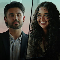 Edris in a suit and Hayley smiling, separated by a diagonal line, indoors with soft light and a blurred background.