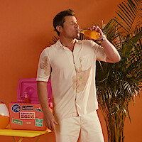 Nick Lachey taking a sip of an orange drink.