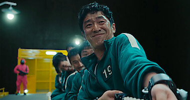 Men playing the tug-of-war game in Squid Game.