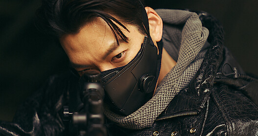 Actor Kim Woo-bin points a gun in a close-up still image from the series 'Black Knight.'