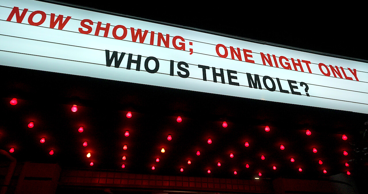 A marquee that reads 'NOW SHOWING; ONE NIGHT ONLY WHO IS THE MOLE?'