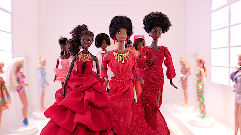 Black Barbie dolls posed together.