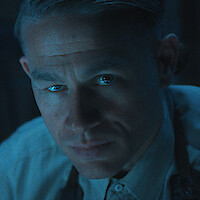A man and woman, seated in a diner booth, share a sweet moment, smiling and holding a piece of paper between them.