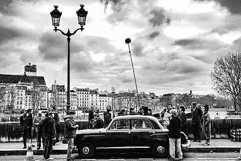 Cast and crew film Nouvelle Vague in the streets of Paris.
