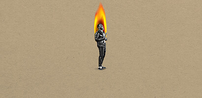 Kevin Hart in black-and-white stands on a tan background, with their head replaced by a large bright flame, suggesting a surreal or artistic concept.