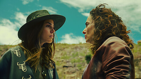 Claudia Alvarez as Antonia and Ana Serradilla as Perla look at each other angrily while outside in an image from 'Sisters' Feud.'