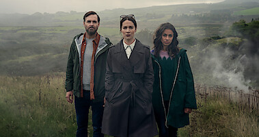 Will Forte as Gilbert Power, Siobhán Cullen as Dove, Robyn Cara as Emmy Sizergh stand together outdoors in 'Bodkin'