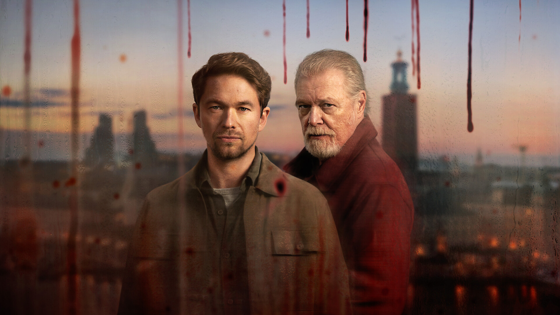 Two serious men stand in front of a cityscape at sunset, viewed through a window streaked with what looks like blood, suggesting a dramatic or crime setting.