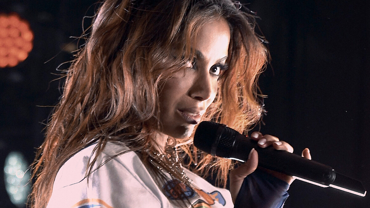 Anitta holding a mic during a performance
