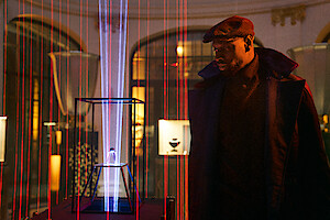 Omar Sy, no papel de Assane Diop, encara um objeto misterioso cercado por lasers vermelhos na temporada 3 de ‘Lupin’.