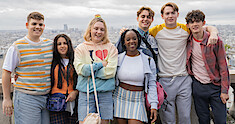The cast of Season 2 of 'Heartstopper' smiles at the camera with the skyline of Paris in the background.