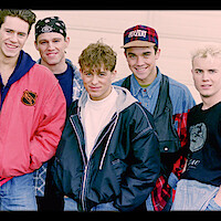 Five members of a boy band smiling