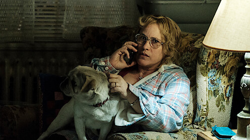 Patricia Arquette as Joyce "Tilly" Mitchell talks on the phone with a dog on her lap in ‘Escape at Dannemora.’