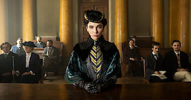 A woman stands in front of a court room