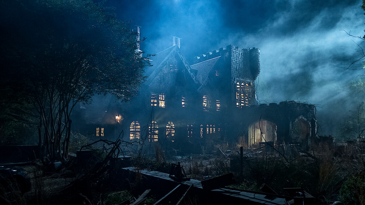 Old, abandoned mansion at night surrounded by overgrown vegetation, eerie mist, and dramatic lighting creating a spooky, haunted atmosphere. Broken windows and ruined walls add to the mysterious, unsettling mood of the scene.