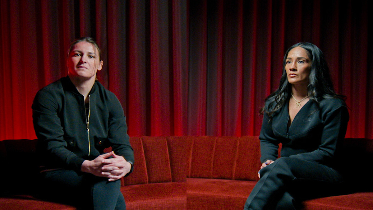 Katie Taylor and Amanda Serrano sitting on a red velvet couch