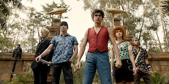 Iñaki Godoy Mackenyu, Emily Rudd standing in a courtyard