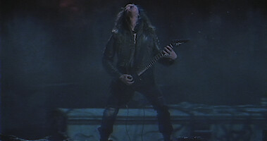 Eddie Munson playing guitar in a night scene.