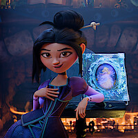Animated girl in a purple dress sits confidently by a fireplace, hand on chest, with a decorative book featuring a glowing princess portrait beside her on a wooden table. Cozy, magical indoor setting with stone walls.