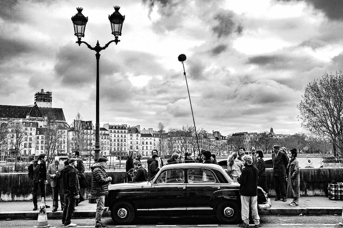 Cast and crew film Nouvelle Vague in the streets of Paris.