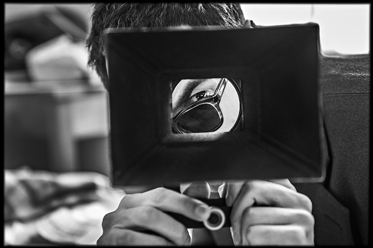 Jean-Luc Godard (Guillaume Marbeck) looks through a viewfinder to frame a shot for Breathless in Nouvelle Vague.