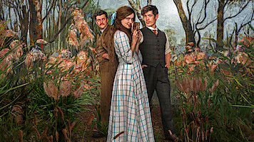 Three people in vintage clothing stand among tall grasses in a lush, painted woodland setting; the central woman in a checked dress is flanked by two men in period suits, all posing dramatically.