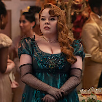 Nicola Coughlan as Penelope Featherington stands at a ball in a dark green gown in Season 3 of 'Bridgerton'