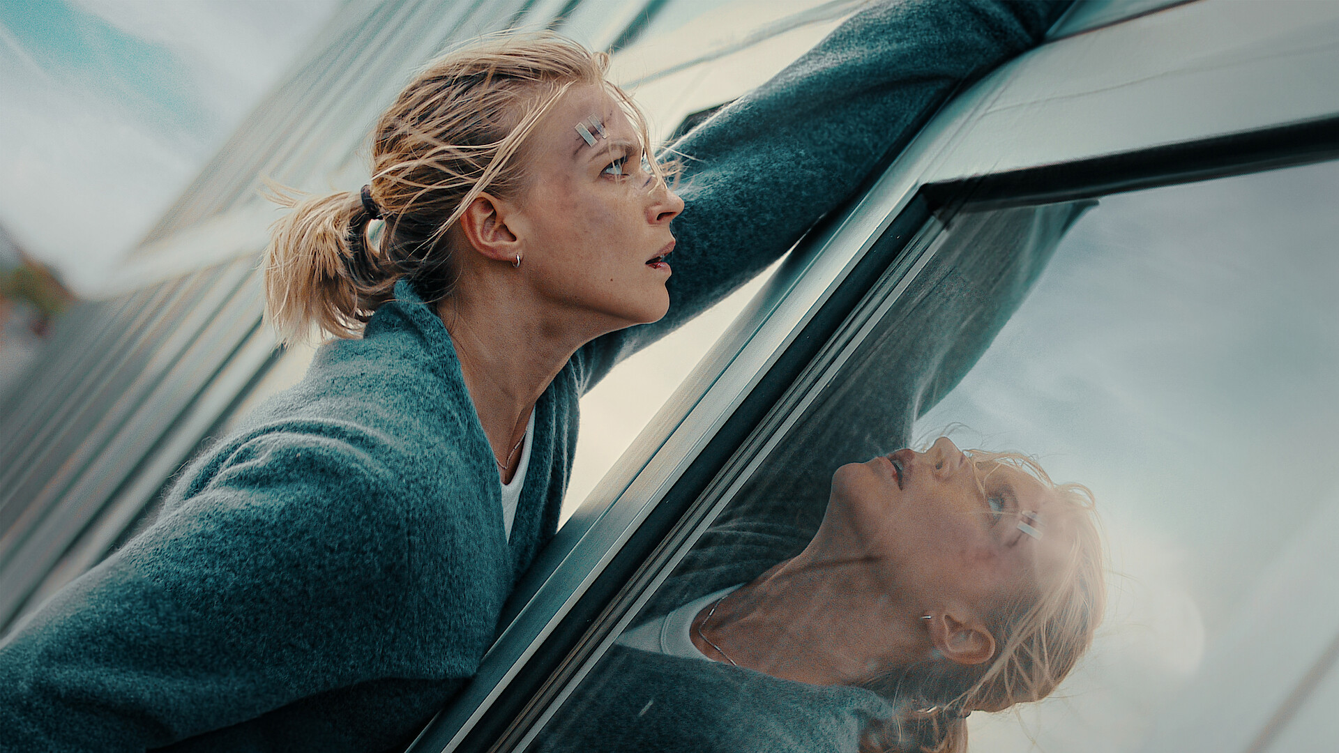 Exterritorial - a woman clutching the exterior side of a skyscraper