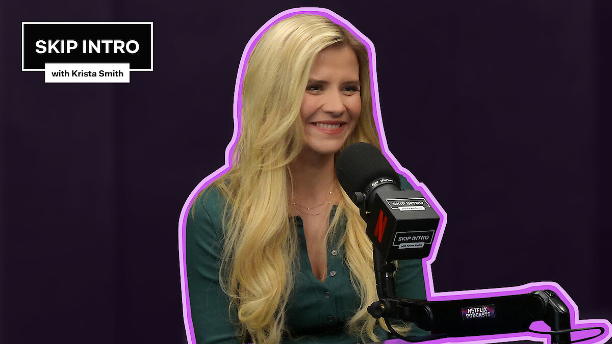 Elizabeth Smart sits smiling in front of a microphone during a podcast recording for "Skip Intro with Krista Smith." The background is purple, and the podcast logo appears in the top left corner.