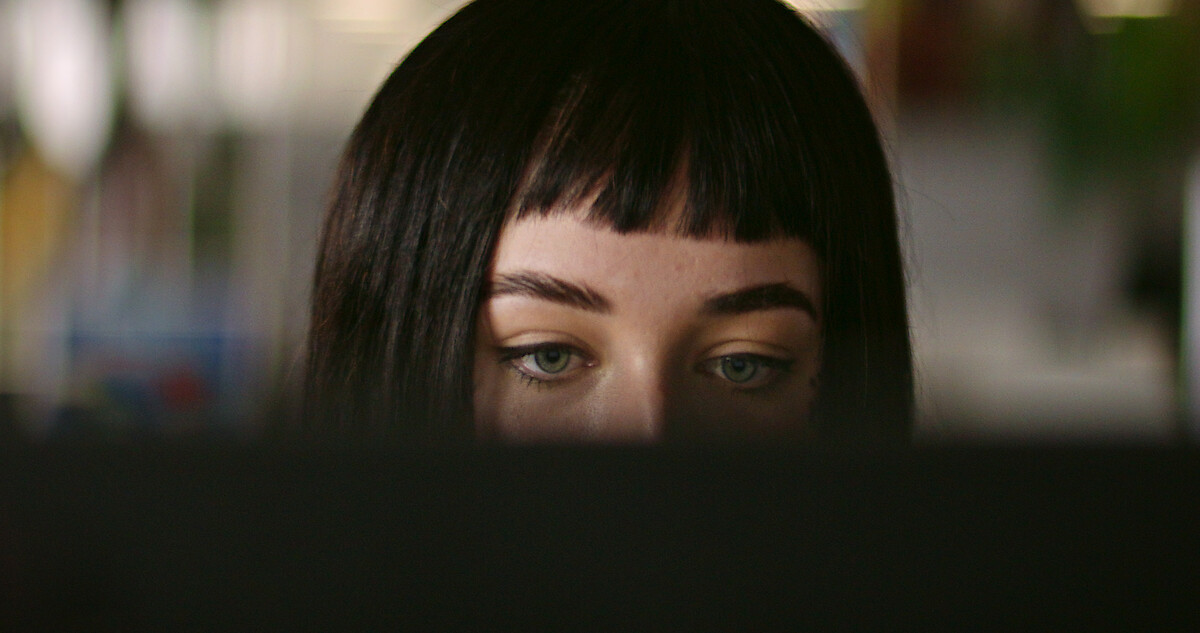 A woman behind a computer monitor.