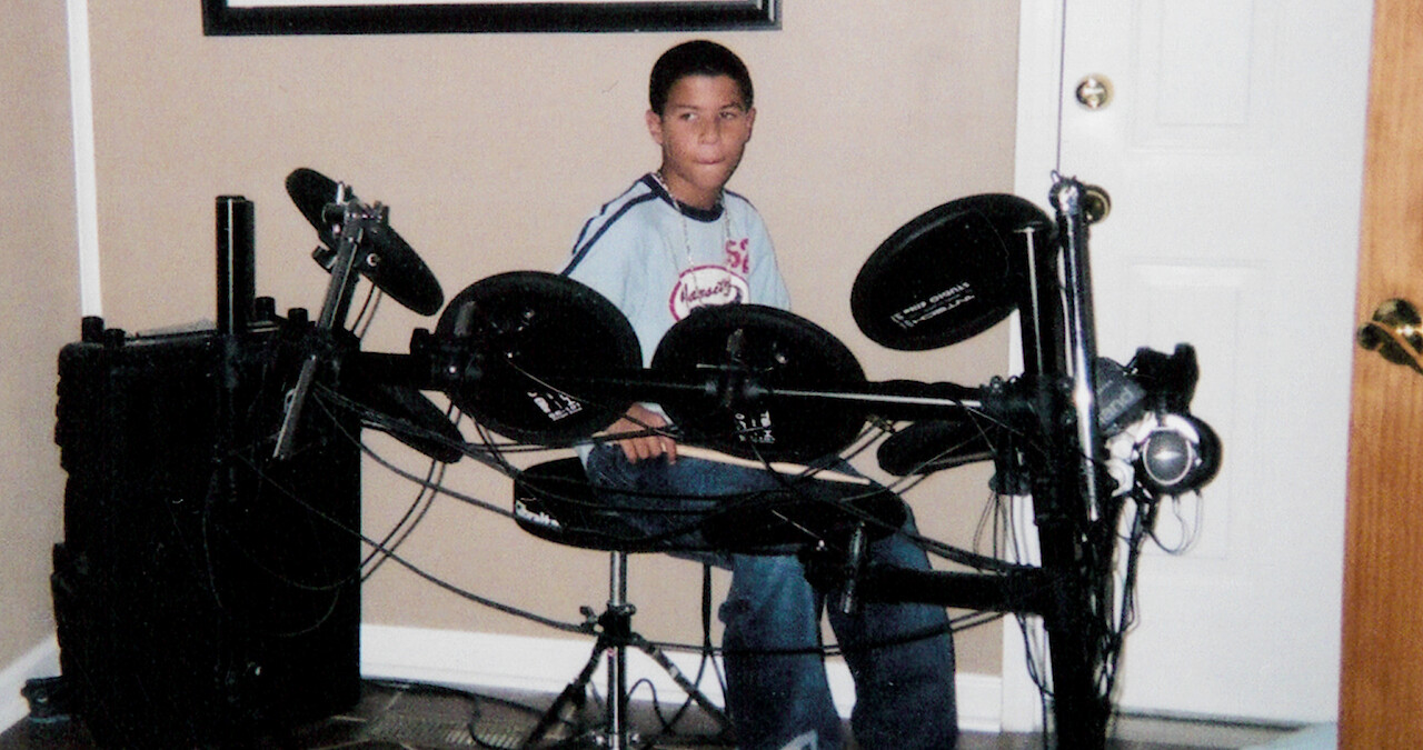 A picture of Bubba Wallace as a teen playing at a drum kit