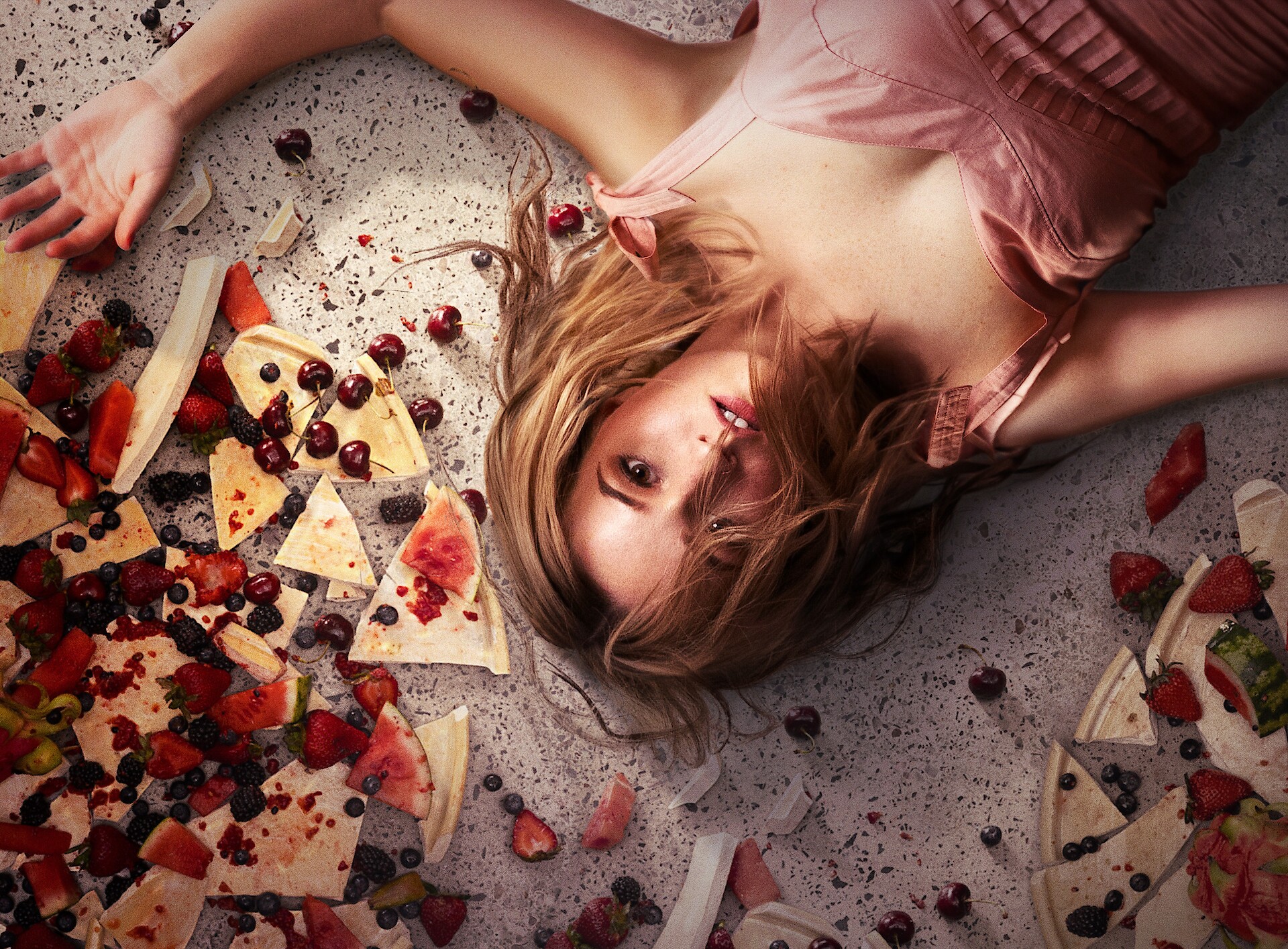 Apple Cider Vinegar key art - A woman on her back surrounded by broken plates, apples, and other stuff