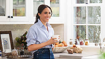 Meghan holding a mug in the kitchen