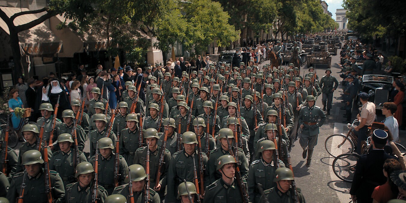 A street filled with columns of soldiers marching. 