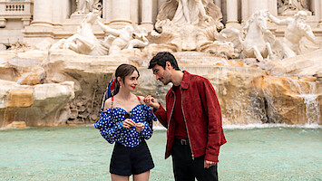 Emily (Lily Collins) diante da Fontana di Trevi, usando uma mochila vermelha em forma de borboleta na temporada 4 de 'Emily em Paris'