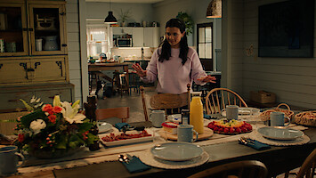 Nikki gesturing towards a grand brunch on a kitchen table