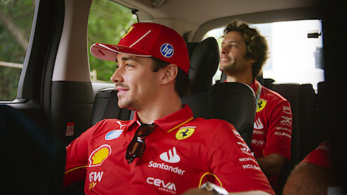 Charles Leclerc rides in a car with his team.