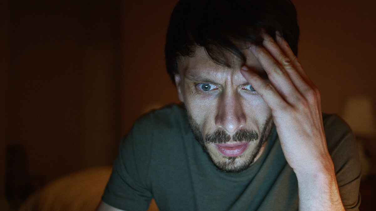 Richard Gadd shows an fearful expression while looking at a bright screen in season 1 of 'Baby Reindeer'