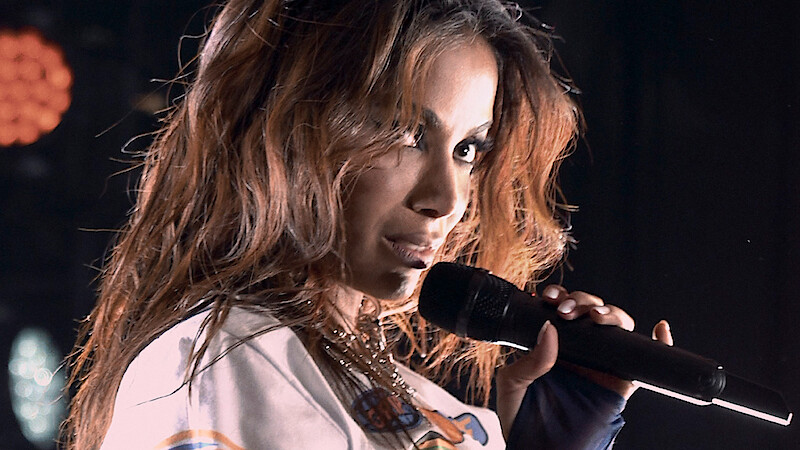 Anitta holding a mic during a performance
