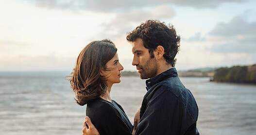 Clara Lago as Ana and Tamar Novas as Daniel embrace on the beach in 'Gangs of Galicia'
