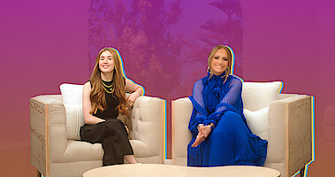 Lucy Paez and Jennifer Lopez sitting on a couch