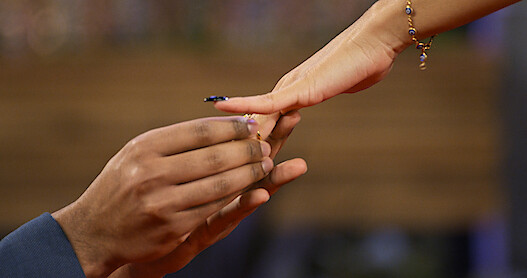 Person slides ring on finger. 