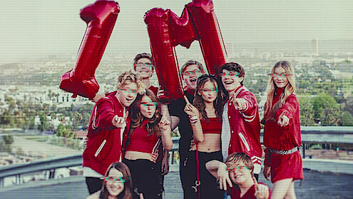 Kidfluencers pose with balloons that say 1M