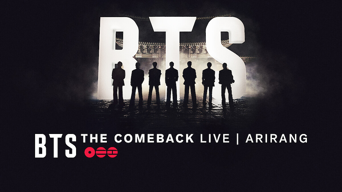 Silhouettes of seven people standing in front of large lit-up BTS letters with "BTS THE COMEBACK LIVE | ARIRANG" text at the bottom, dark concert stage background.