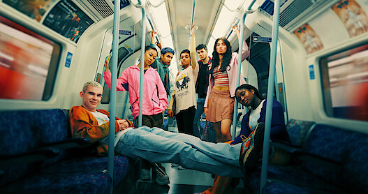 The cast of 'Everything Now S1' rides the London Underground together in Season 1 of 'Everything Now.'