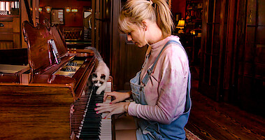 Taylor Swift sitting at a piano during a performance.