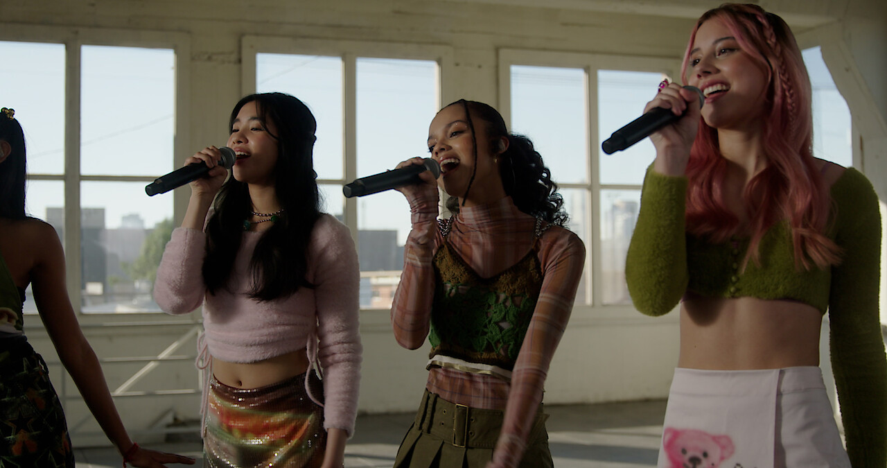 Sophia, Samara, and Celeste sing into microphones.