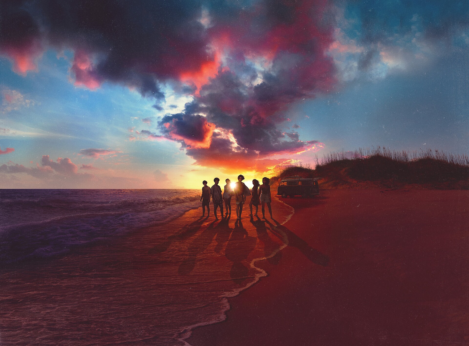 Outer Banks - The cast standing on a beach in front of a sunset