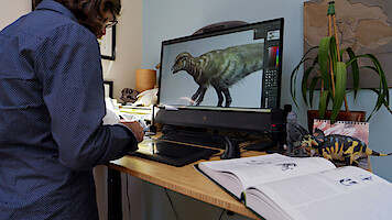 A person works at the computer on 'The Dinosaurs.'