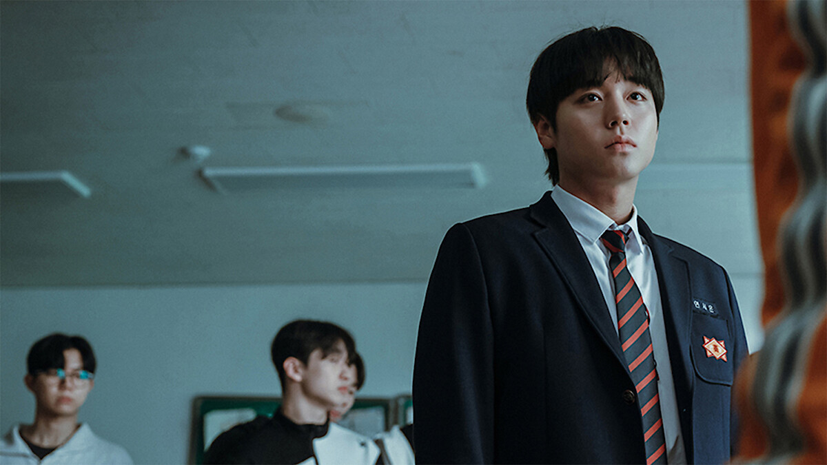  In a classroom, Park Ji-hoon wears a school uniform and stars blankly ahead. 